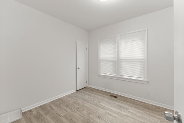 empty room with light hardwood / wood-style flooring