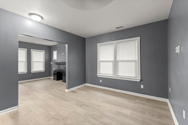 unfurnished living room featuring a fireplace and light wood-type flooring