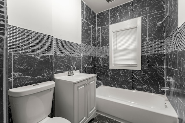 bathroom featuring vanity, toilet, and tile walls