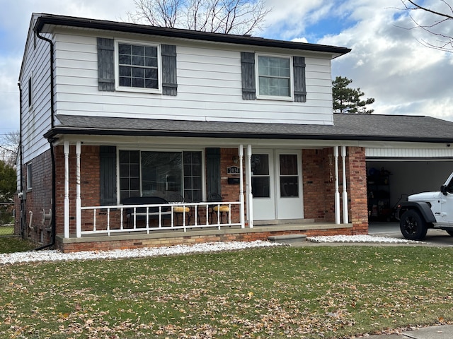 view of property with a front yard, a porch, and a garage