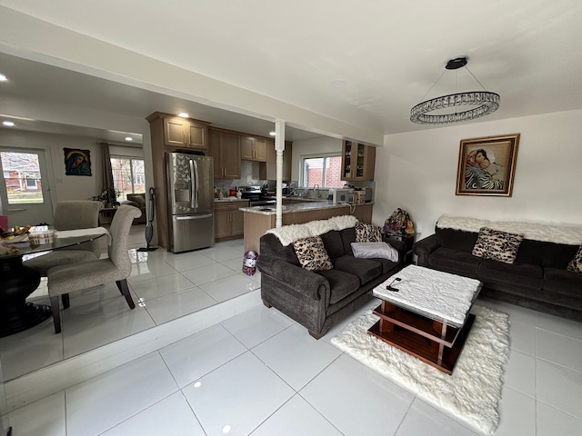 tiled living room with a notable chandelier