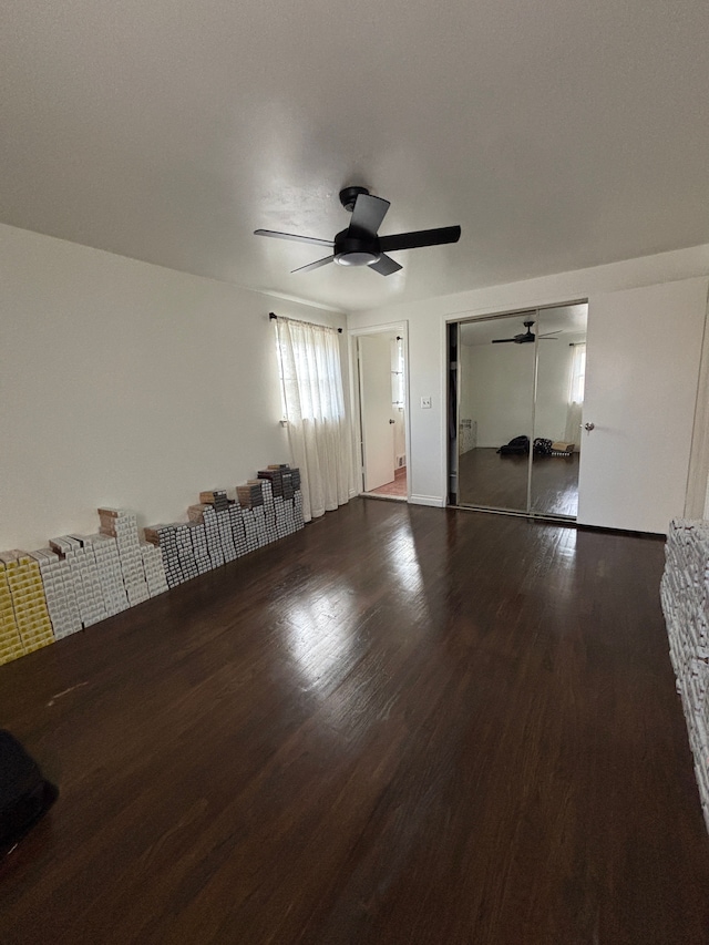 unfurnished bedroom with ceiling fan, wood-type flooring, and a closet