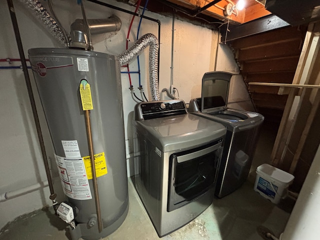 washroom with washing machine and clothes dryer and water heater