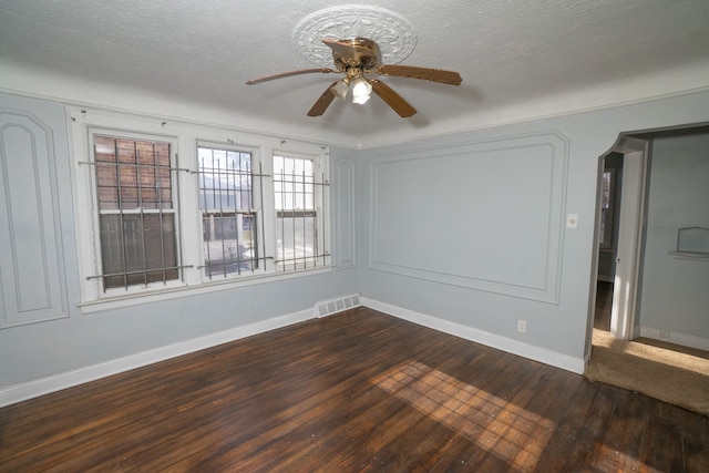 spare room featuring a textured ceiling, dark hardwood / wood-style floors, and ceiling fan