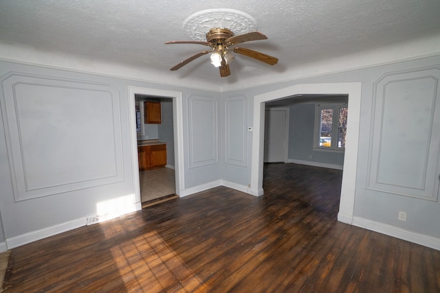 spare room featuring a textured ceiling, dark hardwood / wood-style floors, and ceiling fan