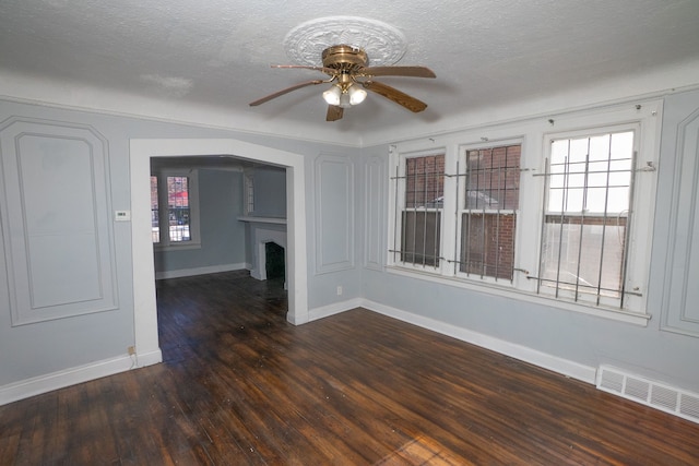 unfurnished room featuring a textured ceiling, ceiling fan, and dark wood-type flooring