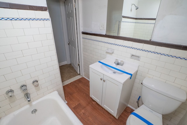 full bathroom with hardwood / wood-style floors, vanity, tile walls, and bathing tub / shower combination