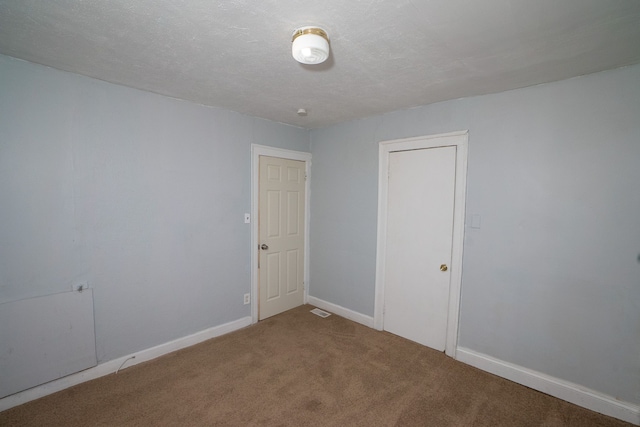 spare room with carpet flooring and a textured ceiling