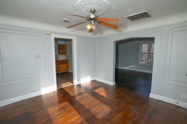 empty room featuring ceiling fan, dark hardwood / wood-style flooring, and a textured ceiling