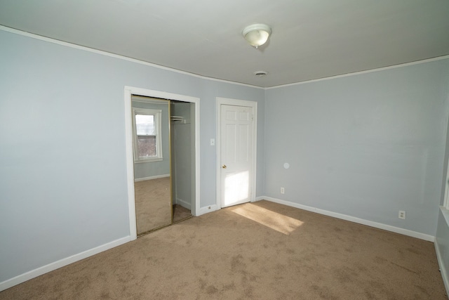 unfurnished bedroom with carpet flooring, a closet, and ornamental molding