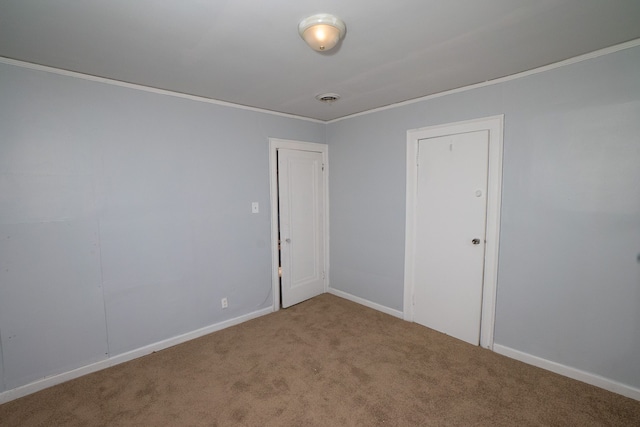 empty room featuring carpet flooring and crown molding