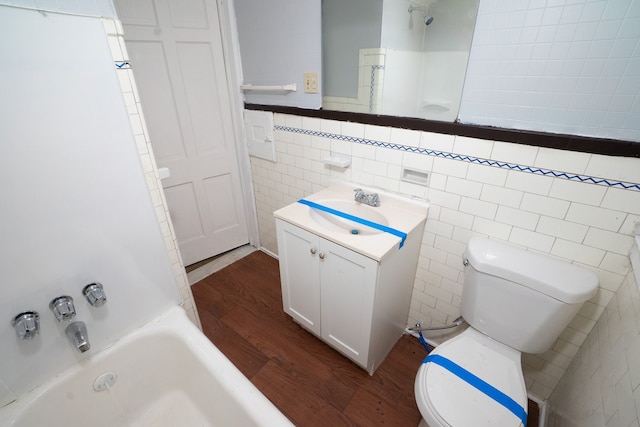 full bathroom with vanity, bathing tub / shower combination, hardwood / wood-style flooring, toilet, and tile walls