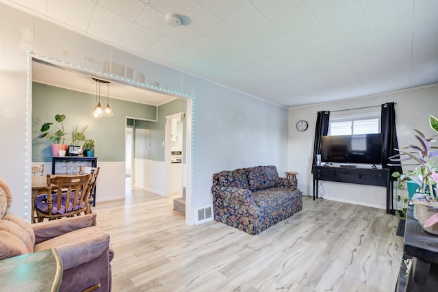 living room with hardwood / wood-style floors and crown molding