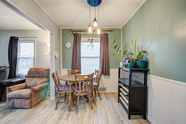 dining area with light hardwood / wood-style floors and crown molding