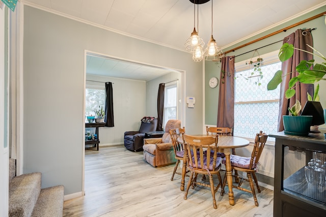 dining space featuring light hardwood / wood-style floors and ornamental molding