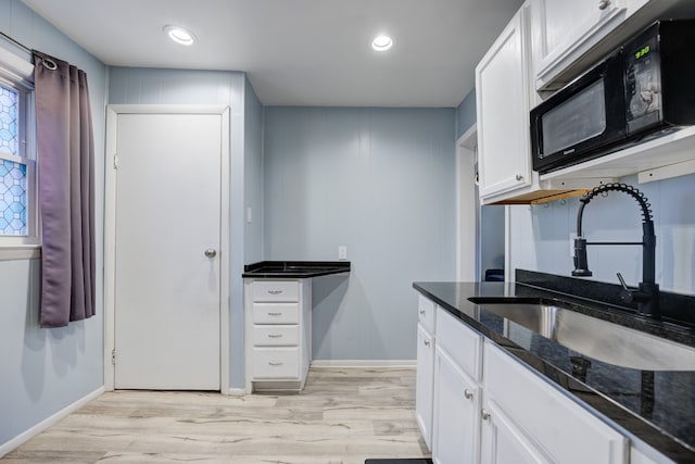 kitchen with white cabinets, light wood-type flooring, and sink