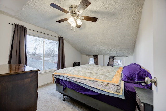 carpeted bedroom with a textured ceiling, ceiling fan, and lofted ceiling