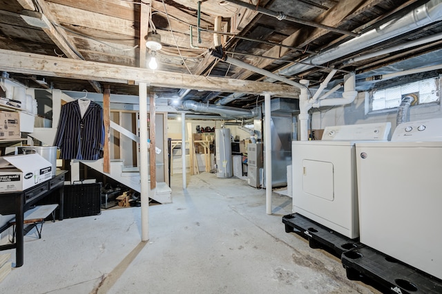 basement with gas water heater, heating unit, and washing machine and clothes dryer