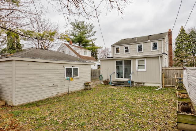 rear view of house with a yard and an outdoor structure