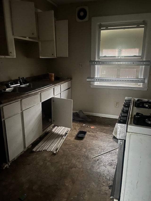 kitchen featuring white gas range oven and sink