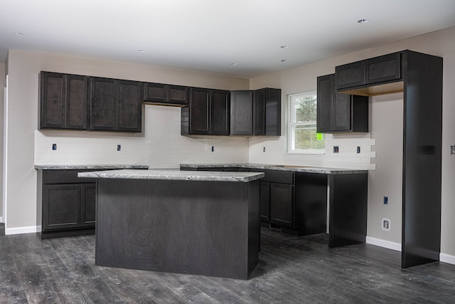 kitchen with dark hardwood / wood-style floors, a kitchen island, and tasteful backsplash