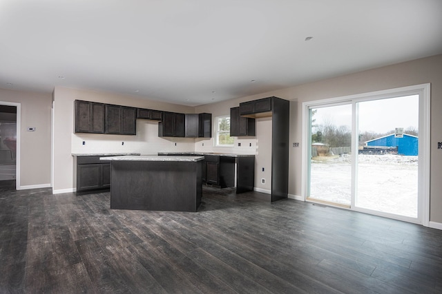 kitchen featuring dark brown cabinetry, a kitchen island, and dark hardwood / wood-style floors