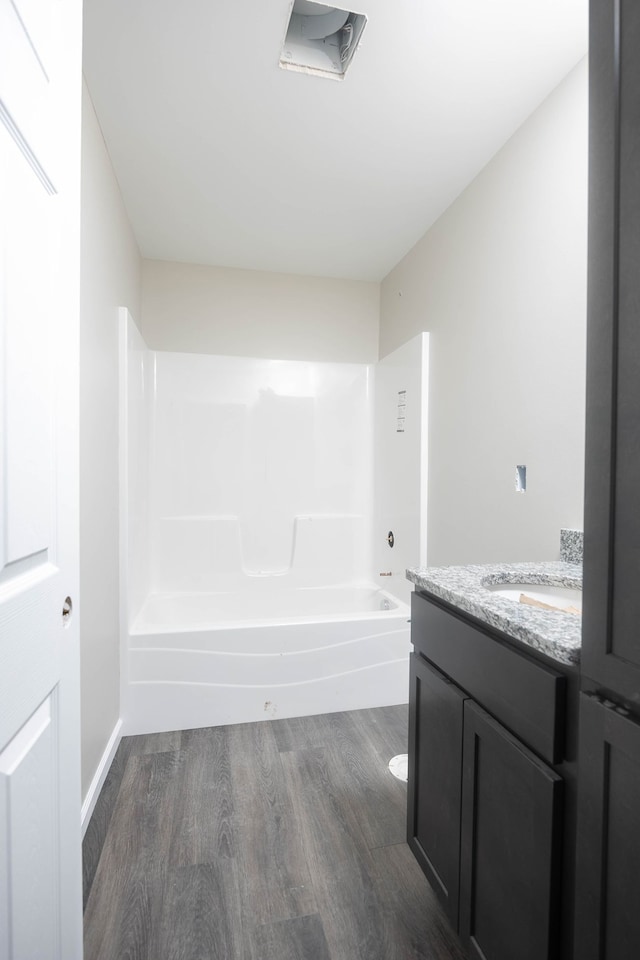 full bathroom featuring hardwood / wood-style flooring, vanity, toilet, and bathing tub / shower combination