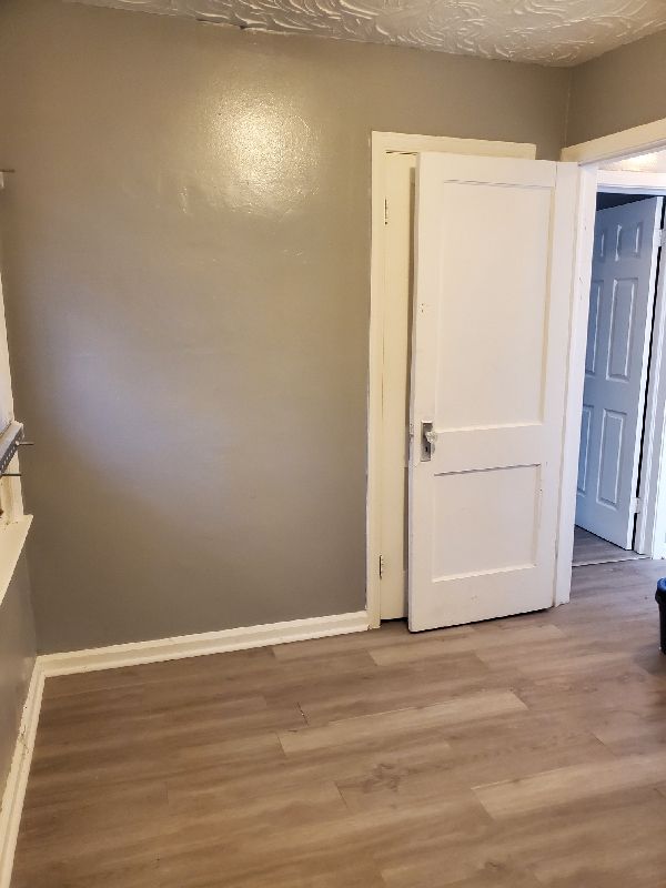 spare room featuring light hardwood / wood-style floors and a textured ceiling