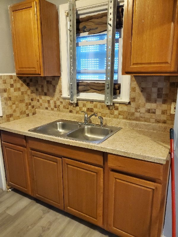 kitchen with light hardwood / wood-style floors, sink, and tasteful backsplash