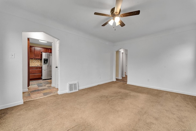 carpeted spare room featuring ceiling fan