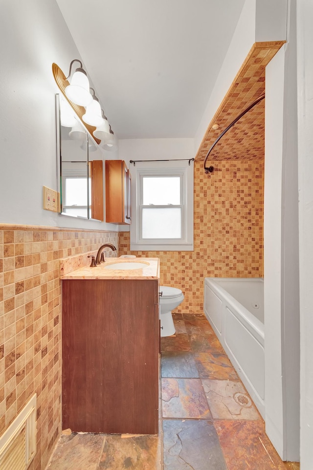 full bathroom featuring vanity, toilet, tile walls, and tub / shower combination