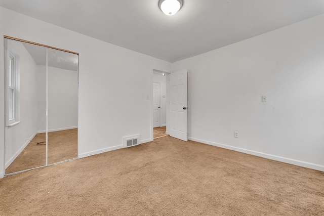 unfurnished bedroom featuring carpet flooring and a closet