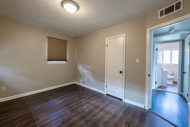 unfurnished bedroom featuring dark hardwood / wood-style floors and a closet