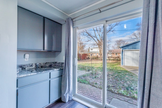 doorway to outside with ornamental molding and dark hardwood / wood-style flooring