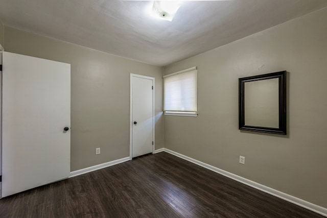 unfurnished room with dark hardwood / wood-style flooring