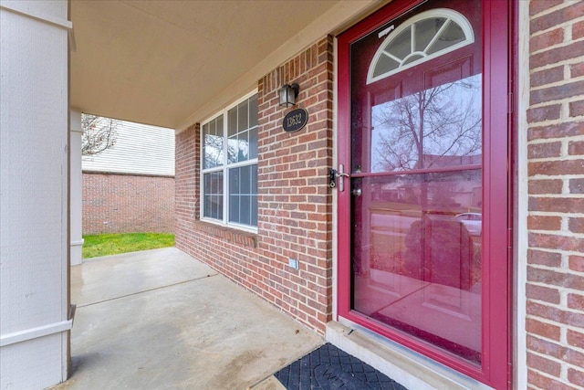 view of exterior entry featuring covered porch