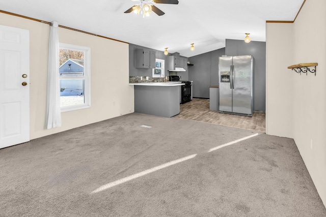 kitchen featuring gray cabinetry, electric range, kitchen peninsula, stainless steel fridge, and lofted ceiling