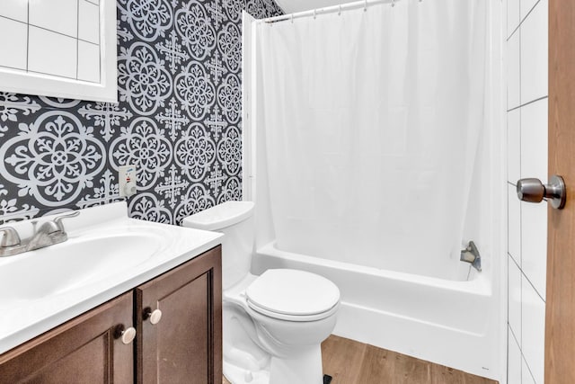 full bathroom featuring hardwood / wood-style floors, vanity, shower / tub combo with curtain, and toilet