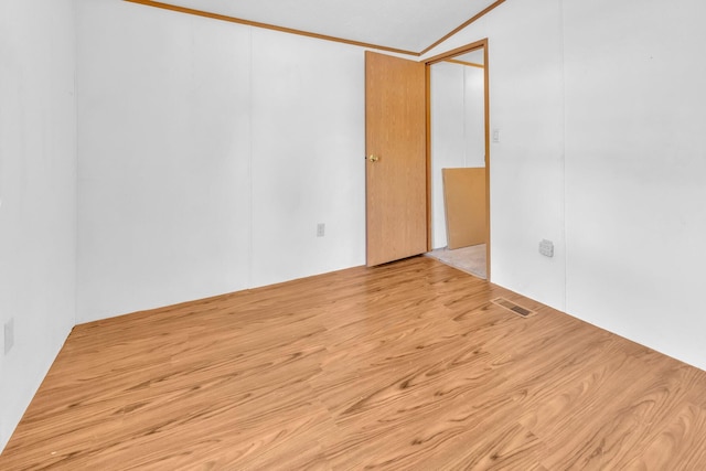 unfurnished room featuring light hardwood / wood-style floors and crown molding