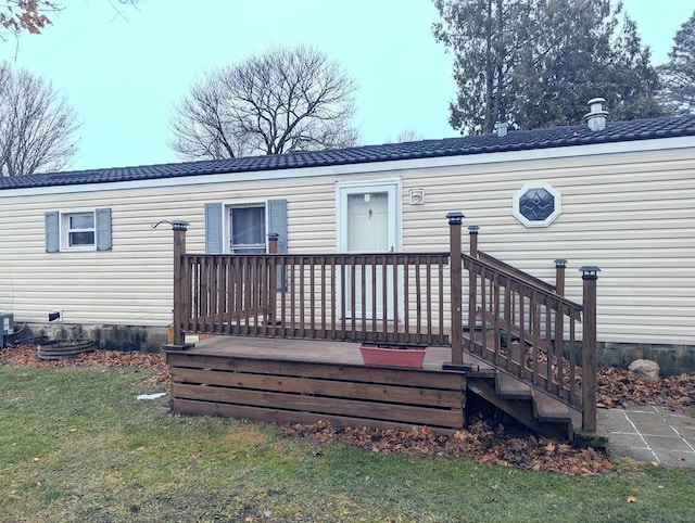 rear view of property featuring a yard and a deck