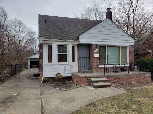 bungalow-style house with brick siding, a chimney, fence, and roof with shingles