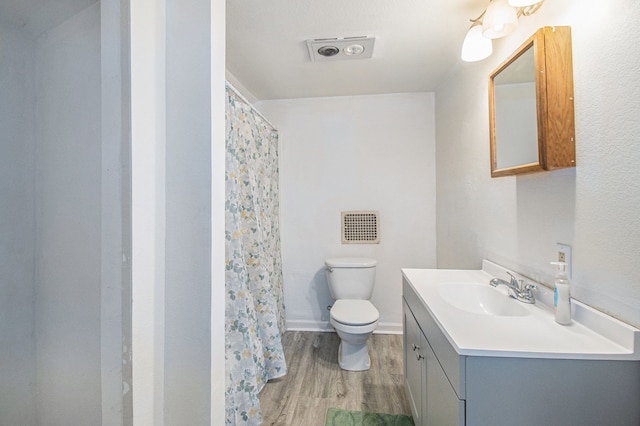 bathroom featuring hardwood / wood-style flooring, vanity, curtained shower, and toilet