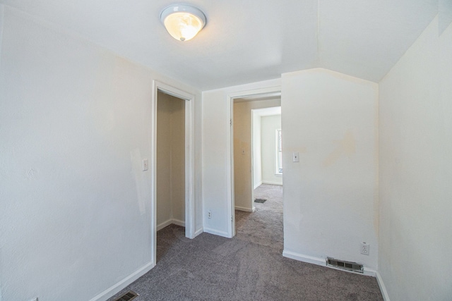 carpeted empty room with lofted ceiling