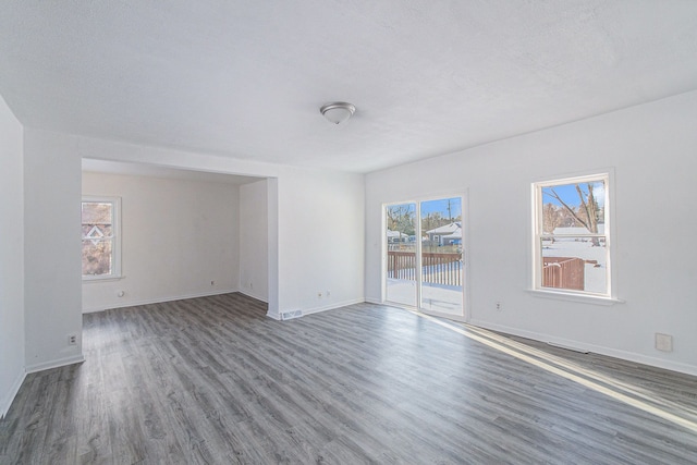 unfurnished room with a textured ceiling, hardwood / wood-style flooring, and plenty of natural light