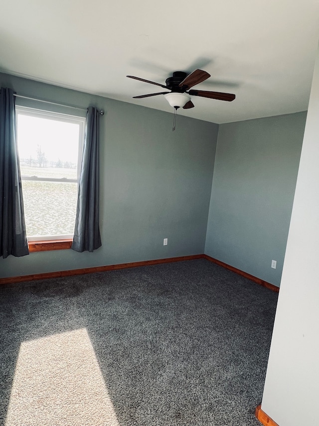 carpeted spare room featuring ceiling fan