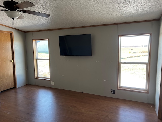 unfurnished room with plenty of natural light, wood-type flooring, and a textured ceiling