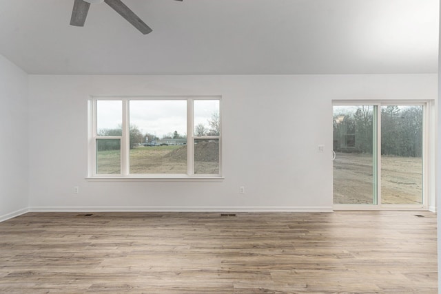 spare room with ceiling fan and light wood-type flooring