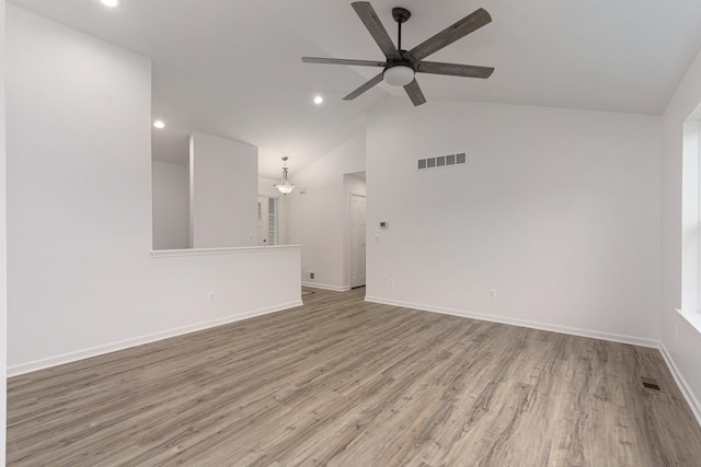 unfurnished living room with hardwood / wood-style flooring, vaulted ceiling, and ceiling fan