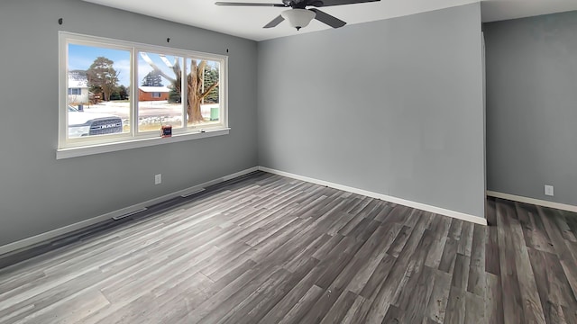 empty room featuring ceiling fan and dark wood-type flooring