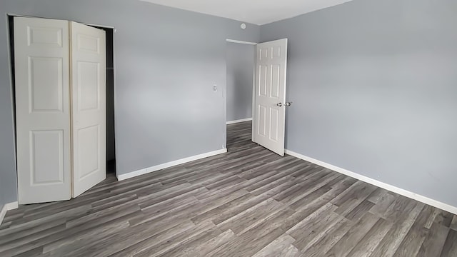 unfurnished bedroom featuring dark hardwood / wood-style floors and a closet